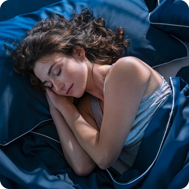 Top view of a young woman sleeping peacefully in bed.